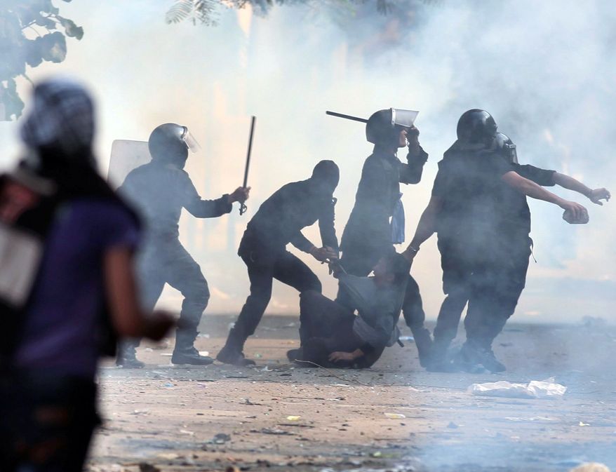 Egyptian security forces arrest a protester on his way to the anti-Morsi rally in Cairo. (Associated Press)