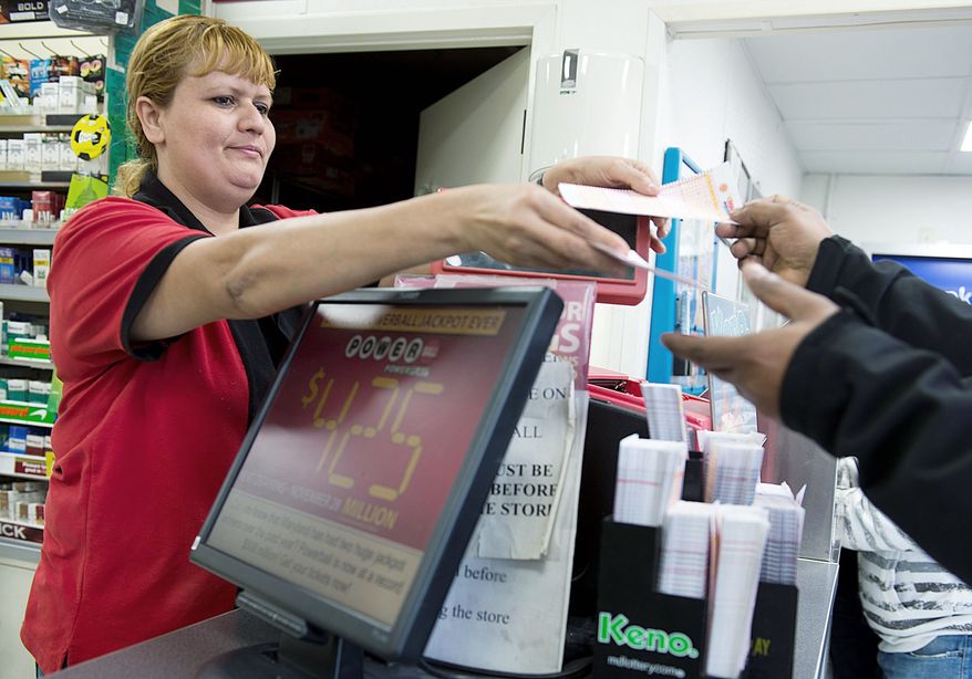Glendy Sanabria sells Powerball tickets at a 7-Eleven in Beltsville on Tuesday, one day ahead of the drawing for more than $500 million. A lot of people in the District, Maryland and Virginia just know that their lottery ticket is the lucky one. (Barbara L. Salisbury/The Washington Times)