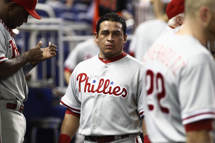 Philadelphia Phillies' Carlos Ruiz stands in the dugout during the first inning of a MLB baseball game in Miami, Sunday, Sept. 30, 2012. (AP Photo/J Pat Carter)
