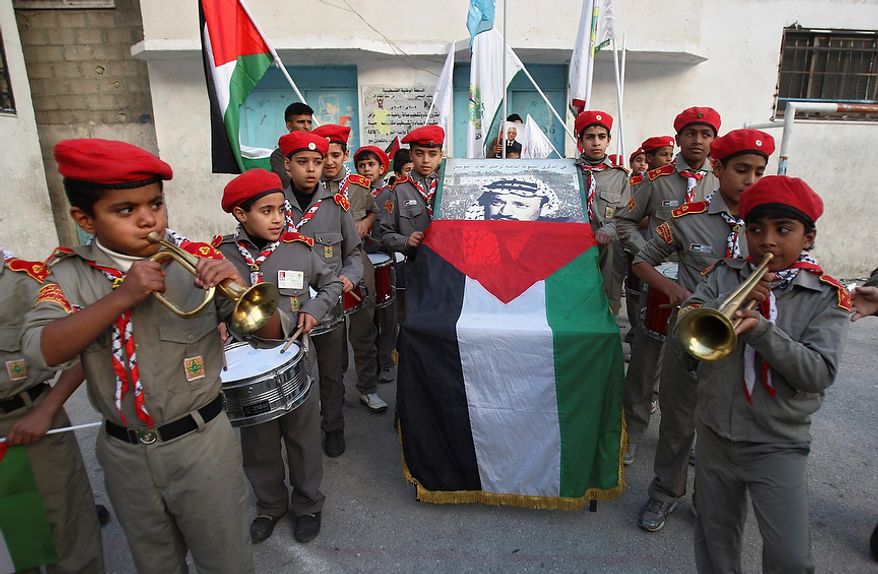 Palestinian boy scouts play music during a symbolic funeral ceremony for late Palestinian leader Yasser Arafat, in Balata refugee camp, near the West Bank city of Nablus, Tuesday, Nov. 27, 2012. Palestinian authorities on Tuesday opened Yasser Arafat's grave and foreign experts took samples from his remains as part of a long-shot attempt, eight years after the iconic leader's mysterious death, to determine whether he was poisoned, as relatives and some political successors have claimed. (AP Photo/Nasser Ishtayeh)