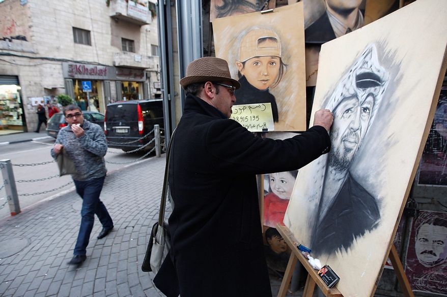 Palestinian artist Abdul Hadi paints a portrait of the late Palestinian leader, Yasser Arafat, in the West Bank city of Ramallah, Tuesday, Nov 27, 2012. Palestinian authorities on Tuesday opened Yasser Arafat's grave and foreign experts took samples from his remains as part of a long-shot attempt, eight years after the iconic leader's mysterious death, to determine whether he was poisoned, as relatives and some political successors have claimed. (AP Photo/Majdi Mohammed)