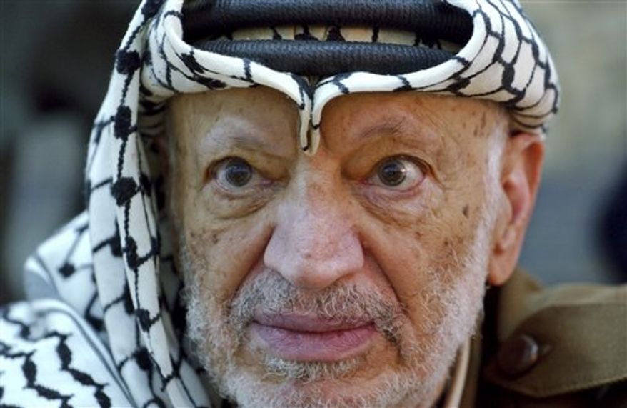 ** FILE ** In this Saturday, Oct. 2, 2004, file photo, Palestinian leader Yasser Arafat pauses during an emergency cabinet session, at his compound, in the West Bank town of Ramallah. The remains of former Palestinian leader Yasser Arafat were exhumed on Tuesday, Nov. 27, 2012, to enable foreign experts to take samples as part of a probe into his death. (AP Photo/Muhammed Muheisen, File)