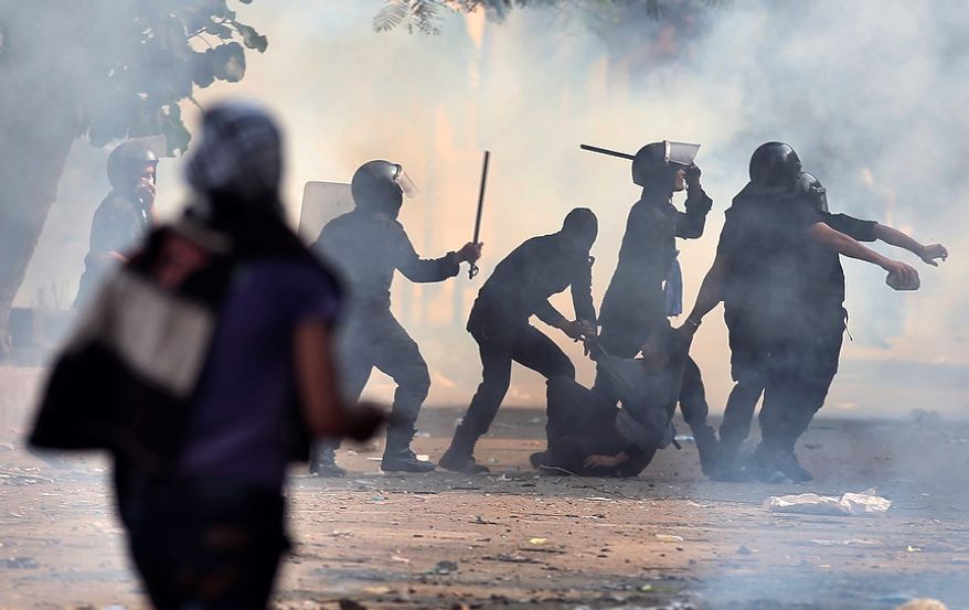 Egyptian security forces arrest a protester during clashes near Tahrir Square in Cairo on Tuesday, Nov. 27, 2012. Demonstrators and police clashed just hours ahead of a planned mass rally by opponents of the country's Islamist president, who are demanding he rescind decrees that granted him near-absolute powers. (AP Photo/Khalil Hamra)