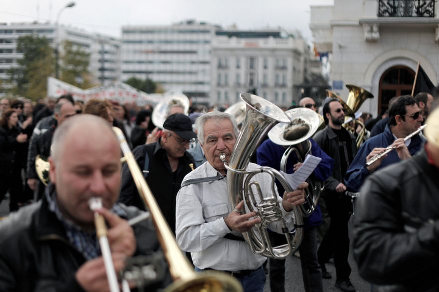 Musicians from a municipal band play during a protest march to the ministry of Administrative Reform in central Athens, Tuesday, Nov. 27, 2012. Several hundred people took part in the peaceful demonstration. Greek municipal workers have occupied hundreds of town halls across the country to protest against government plans to suspend 2,000 civil servants for potential dismissal due to state budget cuts. (AP Photo/Petros Giannakouris)