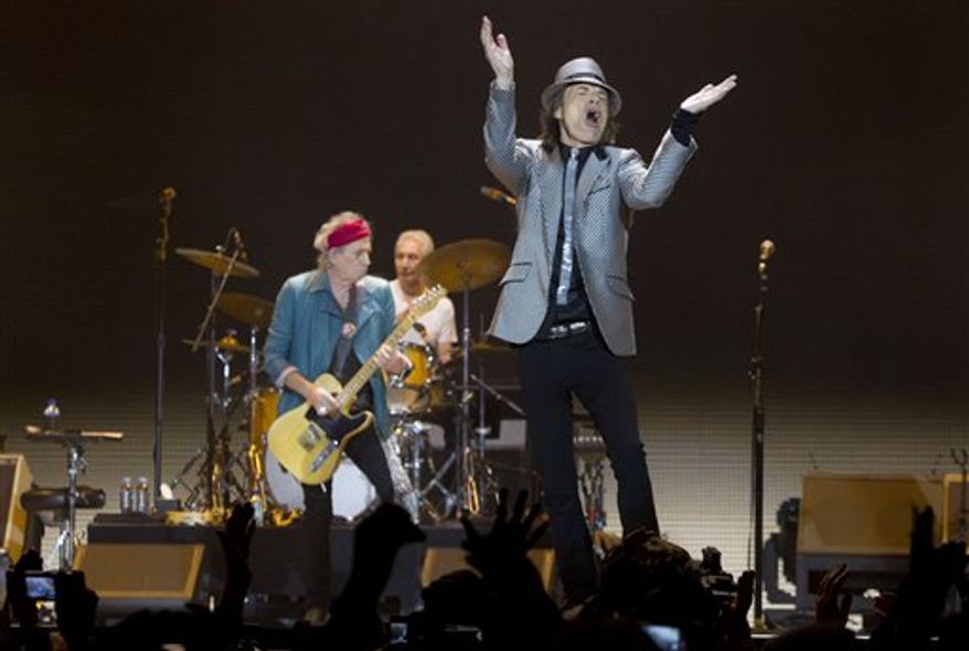 Mick Jagger, right and Keith Richards, left, and Charlie Watts behind, of The Rolling Stones perform at the O2 arena in east London, Sunday, Nov. 25, 2012. The band are playing four gigs to celebrate their 50th anniversary, including two shows at London’s O2 and two more in New York. (Invision via Associated Press)
