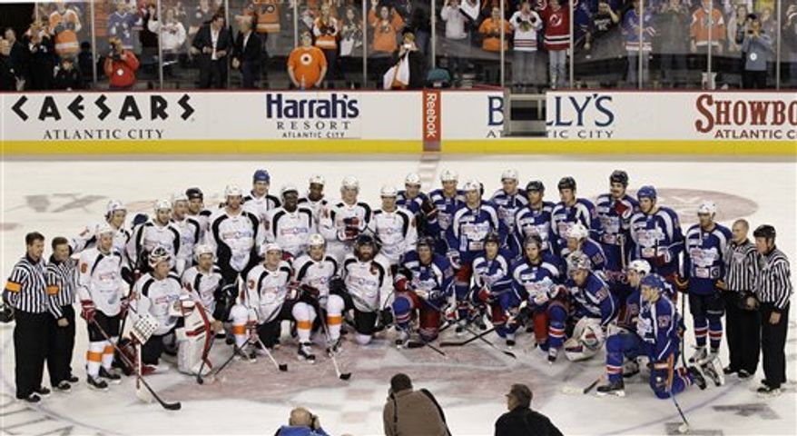 The New Jersey Team, left, and the New York Team pose for photographs after a charity hockey game in Atlantic City, N.J., Saturday, Nov. 24, 2012. New York won 10-6. (AP Photo/Mel Evans)