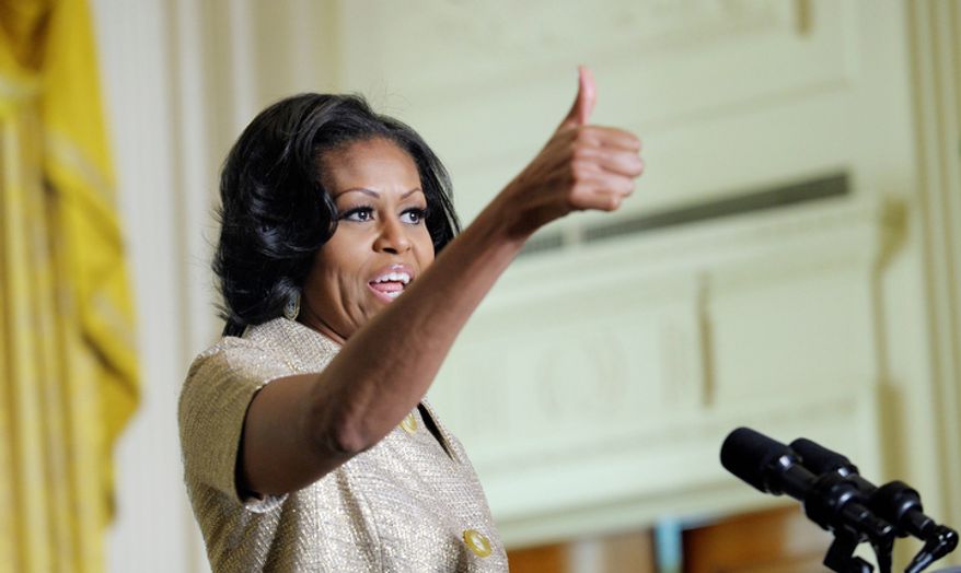 First lady Michelle Obama gives a thumbs up to those who decorated the White House as she speaks to military families in the East Room of the White House in Washington, Wednesday, Nov. 28, 2012. The theme for the White House Christmas 2012 is Joy to All.  (AP Photo/Susan Walsh)