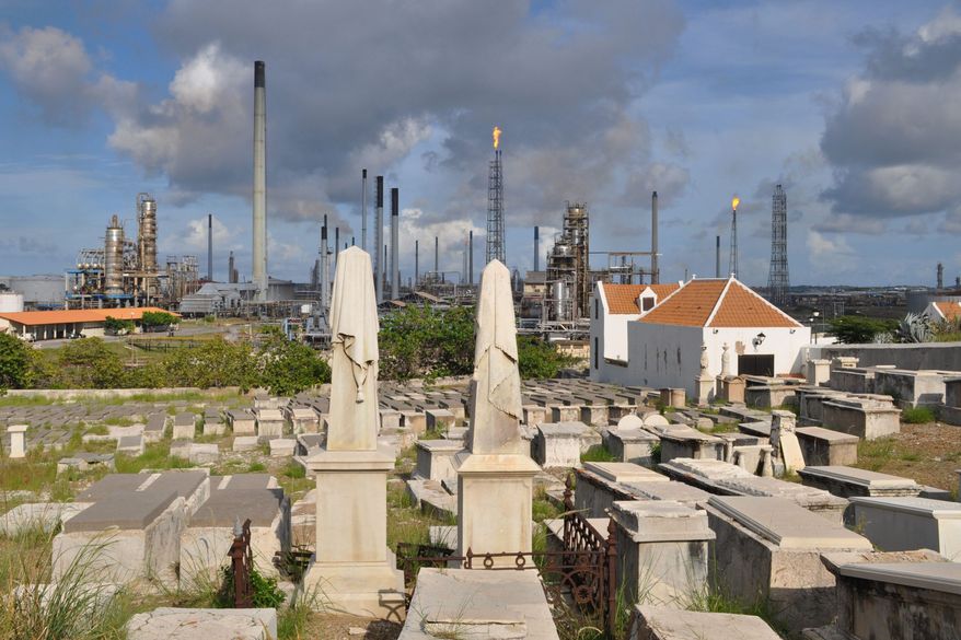 A portion of the Beth Haim cemetery, backdropped by the Isla oil refinery, is seen in Blenheim, on the outskirts of Willemstad, Curacao. (Associated Press)