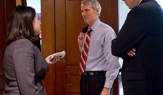 Sen. Rob Portman (center), Ohio Republican, center, talks with a reporter about the closed-door briefing he and other members of the Homeland Security and Governmental Affairs Committee received about the Benghazi attack on Thursday, Nov. 29, 2012, at the U.S. Capitol. (Barbara L. Salisbury/The Washington Times)