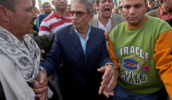 Former foreign minister and presidential candidate Amr Moussa, center, greets supporters as he arrives to Tahrir Square to join other liberal and secular parties for a major protest against Egyptian President Mohammed Morsi&#39;s latest decrees granting himself almost complete powers and allowing a rushed constitution to be presented for a vote, Friday, Nov. 30, 2012. (AP Photo/Thomas Hartwell)