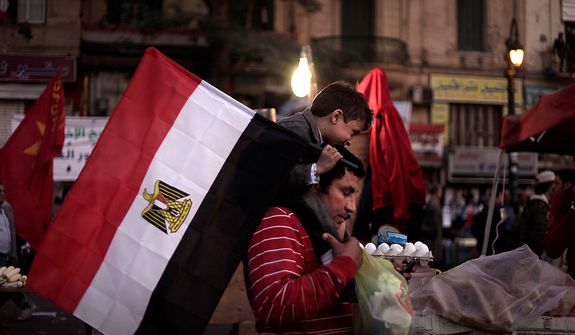 An Egyptian man carries his son during a demonstration in Tahrir Square, Cairo, Egypt, Friday, Nov. 30, 2012. Liberal and secular parties held major protests against Egyptian President Mohammed Morsi&#39;s latest decrees granting himself almost complete powers. (AP Photo/Nariman El-Mofty)