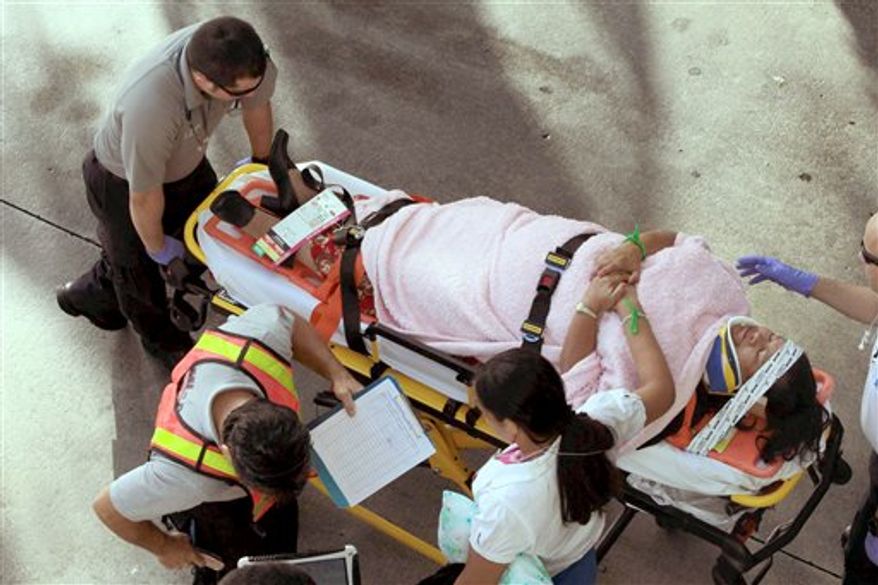 Emergency personnel attend to injured passengers after a bus accident at Miami International Airport on Saturday, Dec. 1, 2012, in Miami. (AP Photo/El Nuevo Herald, Roberto Koltun)