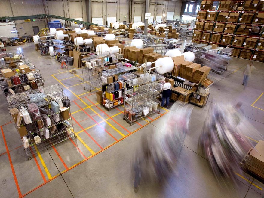 **FILE** Carts full of merchandise ordered on the Internet are rolled to the main packing area for shipping at an Overstock.com warehouse in Salt Lake City. (Associated Press)