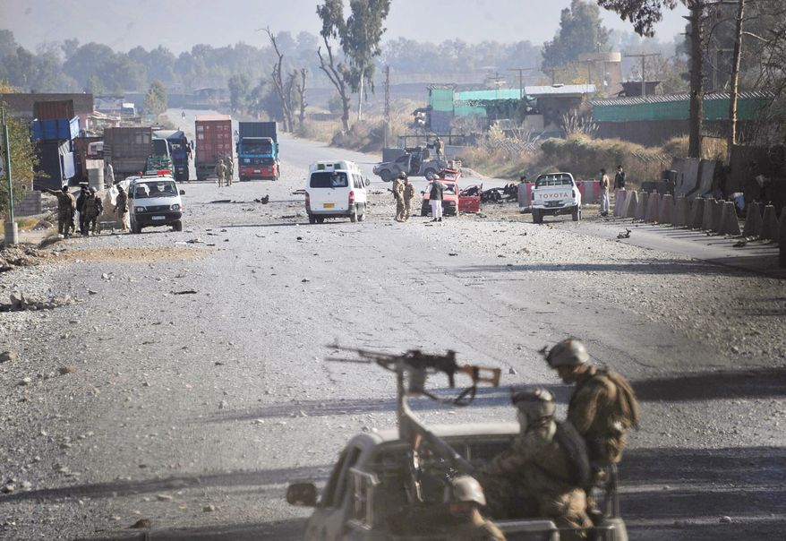 Afghan security forces block the road where Taliban suicide bombers attacked a joint U.S.-Afghan air base in Jalalabad, east of Kabul, Afghanistan, on Sunday, Dec. 2, 2012. The suicide bombers detonated explosives at the gate, and sparking a gunbattle that lasted at least two hours, with American helicopters firing down at militants before the attackers were defeated. (AP Photo/Nasrullah Khan)