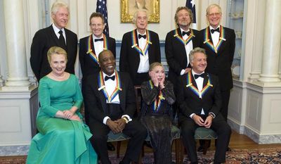 Ballerina Natalia Makarova (front row, second from right) reacts to all the photos being taken during a group photo for the Kennedy Center Honoress after a State Department dinner on Saturday, Dec. 1, 2012, in Washington. From left are former President Bill Clinton, Secretary of State Hillary Rodham Clinton, John Paul Johns, Buddy Guy, Jimmy Page, Miss Makarova, Robert Plant, Dustin Hoffman and David Letterman. (AP Photo/Kevin Wolf)