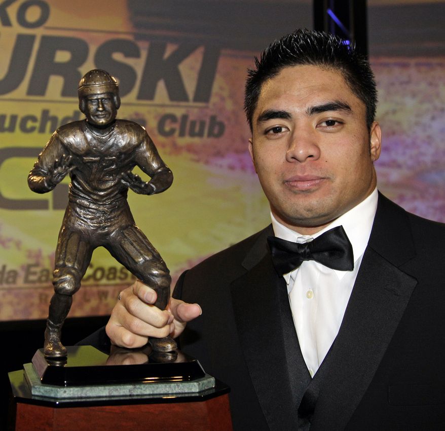 Notre Dame linebacker Manti Te’o poses with the Bronko Nagurski Trophy during a news conference in Charlotte, N.C., Monday, Dec. 3, 2012. The award is given annually to the national collegiate defensive player of the year. (AP Photo/Chuck Burton)