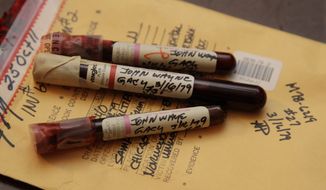 This photo taken Nov. 30, 2012, in Chicago shows three vials of mass murderer John Wayne Gacy&#39;s blood recently discovered by Cook County Sheriff&#39;s detective Jason Moran. The sheriff’s office is creating DNA profiles from the blood of Gacy and other executed killers and putting them in a national DNA database of profiles created from blood, semen, or strands of hair found at crime scenes and on the bodies of victims. What they hope to find is evidence that links the long-dead killers to the coldest of cold cases and prompt authorities in other states to submit the DNA of their own executed inmates and maybe evidence from decades-old crime scenes to help them solve their own cases. (Associated Press)