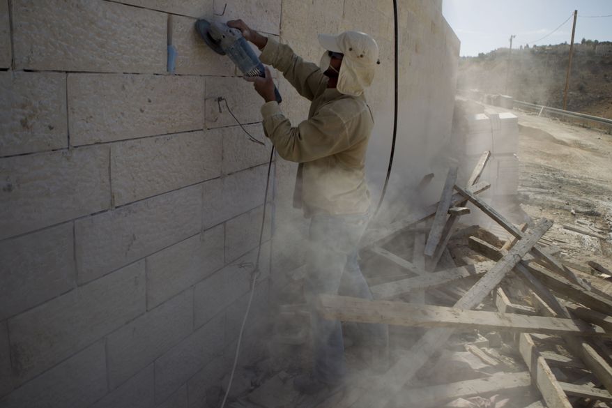 A Palestinian man works Dec. 2, 2012, at a new housing development in the Jewish West Bank settlement of Maaleh Adumim, near Jerusalem. (Associated Press)