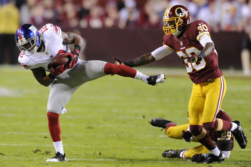 New York Giants wide receiver Jerrel Jernigan (12) hauls in a first down reception in front of Washington Redskins defensive back DJ Johnson (30) and cornerback Josh Wilson (26) in the first quarter at FedEx Field, Landover, Md., Dec. 3, 2012. (Preston Keres/Special to The Washington Times)