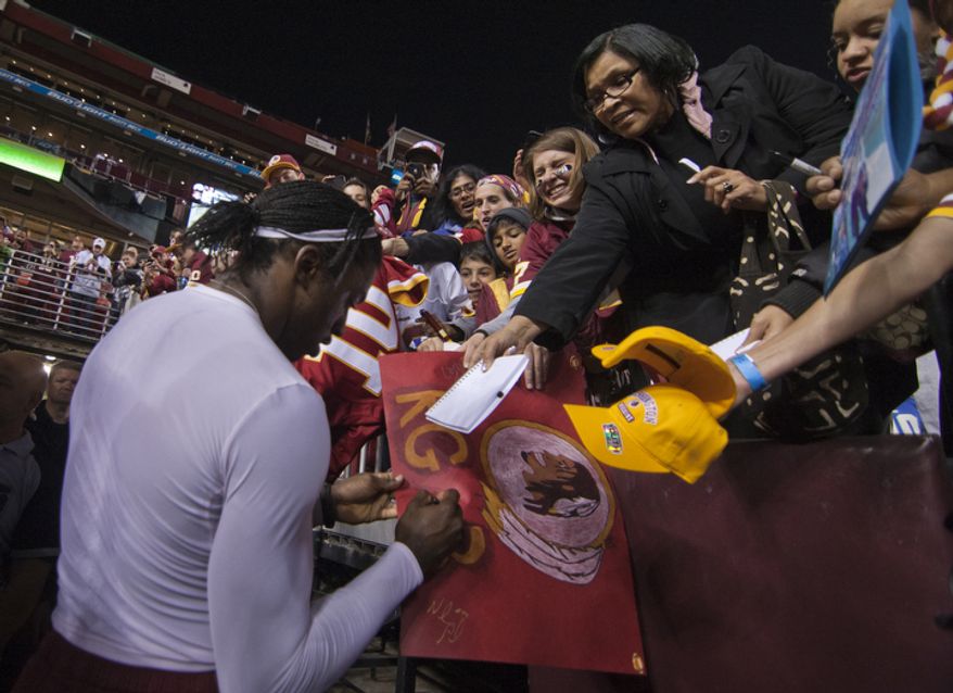 Washington Redskins quarterback Robert Griffin III (10) signs autographs before playing host to the New York Giants on Monday Night Football at FedEx Field, Landover, Md., Monday, December 3, 2012. (Craig Bisacre/The Washington Times)