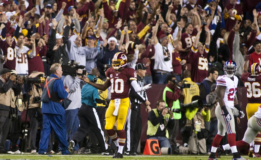 Washington Redskins quarterback Robert Griffin III (10) after fumbling the ball which was recovered and ran in for a touchdown by wide receiver Josh Morgan (15) in the first quarter against the New York Giants, Landover, Md., Monday, December 3, 2012. (Craig Bisacre/The Washington Times)
