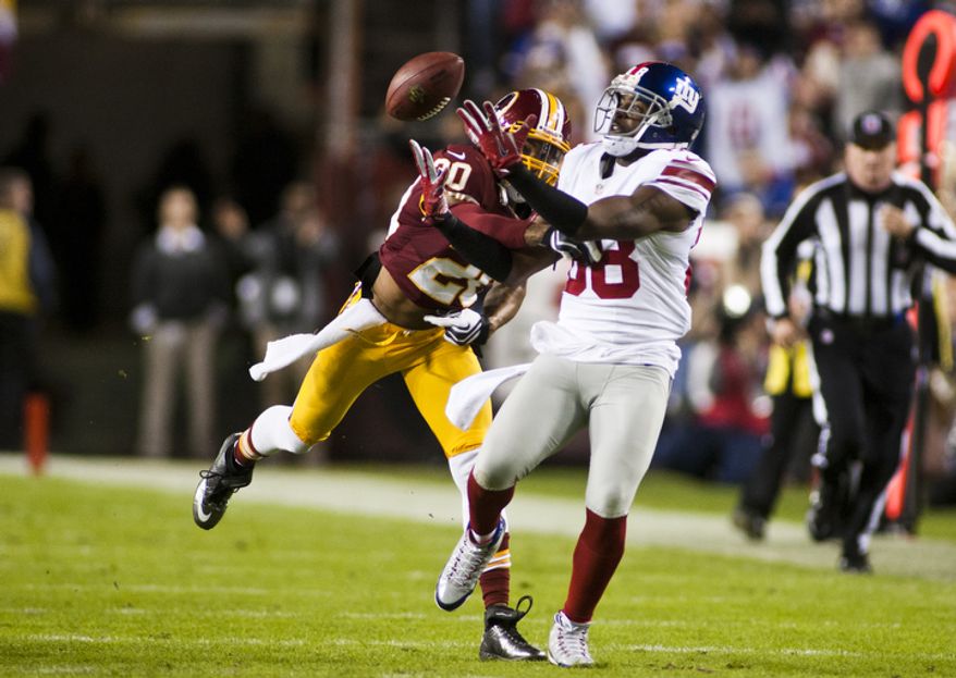 Washington Redskins defensive back Cedric Griffin (20) breaks up a pass intended for New York Giants wide receiver Hakeem Nicks (88) in the first quarter, Landover, Md., Monday, December 3, 2012. (Craig Bisacre/The Washington Times)