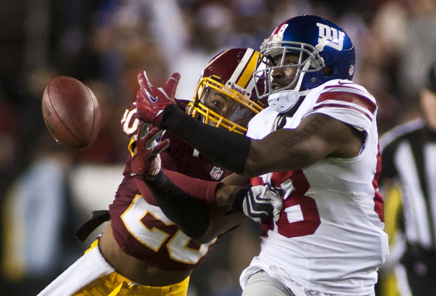 Washington Redskins defensive back Cedric Griffin (20) breaks up a pass intended for New York Giants wide receiver Hakeem Nicks (88) in the first quarter, Landover, Md., Monday, December 3, 2012. (Craig Bisacre/The Washington Times)