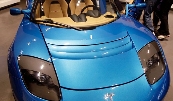 **FILE** People look at electric car Tesla Motors vehicle at a showroom in San Jose, Calif., on May 25, 2011. (Associated Press)