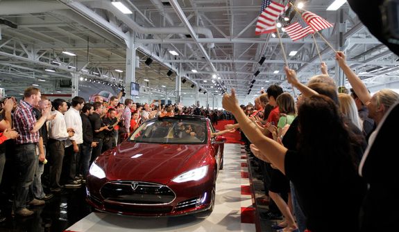 **FILE** Tesla workers cheer on the first Tesla Model S cars sold during a rally at the Tesla factory in Fremont, Calif., on June 22, 2012. (Associated Press)
