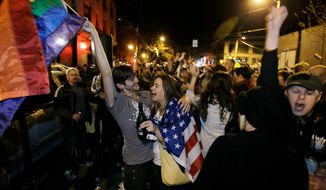 **FILE** Revelers display American and gay pride flags as they celebrate early election returns favoring Washington state&#39;s Referendum 74, which would legalize gay marriage, during a large impromptu street gathering in Seattle&#39;s Capitol Hill neighborhood in the early hours of Nov. 7, 2012. (Associated Press)