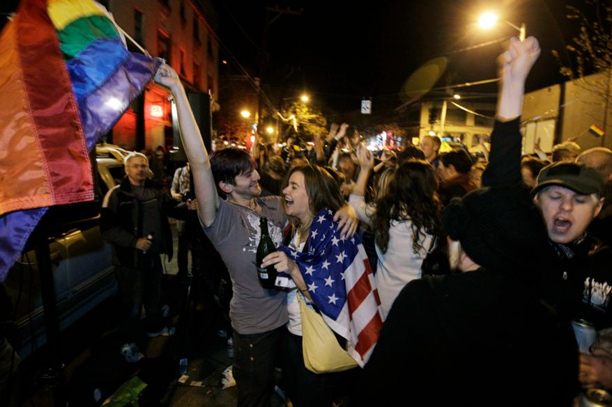 **FILE** Revelers display American and gay pride flags as they celebrate early election returns favoring Washington state's Referendum 74, which would legalize gay marriage, during a large impromptu street gathering in Seattle's Capitol Hill neighborhood in the early hours of Nov. 7, 2012. (Associated Press)