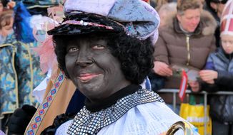 A person dressed as Zwarte Piet, or Black Pete, attends a parade after Sinterklaas, as the Dutch call Santa Claus, arrived by boat in Amsterdam on Sunday, Nov. 18, 2012. (AP Photo/Margriet Faber)