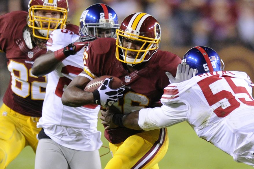 Washington Redskins running back Alfred Morris (46) runs for an 8-yard gain against New York Giants outside linebacker Keith Rivers (55) and free safety Antrel Rolle (26) in the first quarter at FedEx Field, Landover, Md., Dec. 3, 2012. (Preston Keres/Special to The Washington Times)