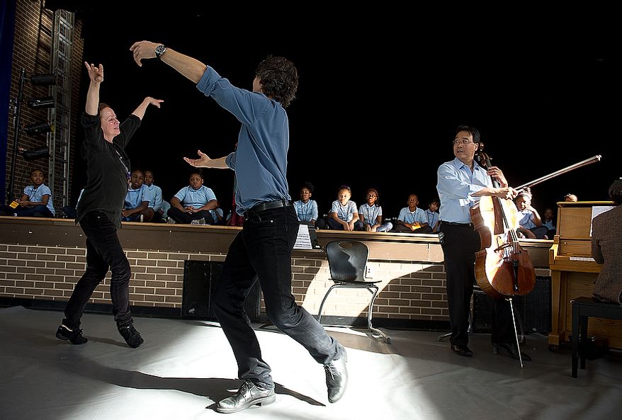While Savoy Elementary School students and cellist Yo Yo Ma look on, Heather Watts and her husband Damian Woetzel, who both used to dance with the New York City Ballet, perform a pas de deux at the Southeast Washington, D.C. school on Tuesday, Dec. 4, 2012. The artists came to the school to lead a small private workshop with some students and then performed with those students for the entire school. (Barbara L. Salisbury/The Washington Times)