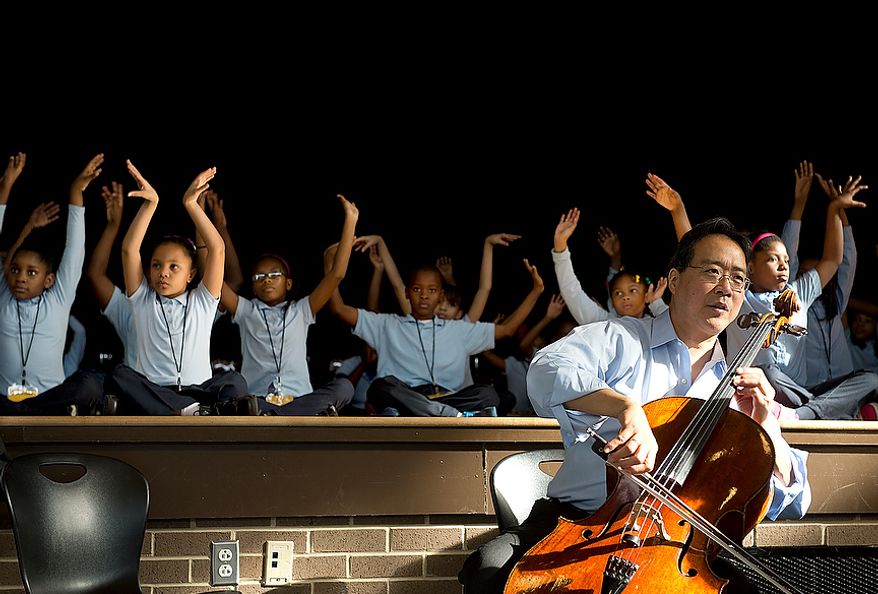 Savoy Elementary School students stretch like swans while world renowned cellist Yo Yo Ma plays "The Swan" during a performance at the Southeast Washington, D.C. school on Tuesday, Dec. 4, 2012. The cellist came to the school with another artist, Damian Woetzel, who used to dance with the New York City Ballet, to run a small private workshop with some of the children as part of the school's Innovtive Schedule for the Arts, which integrates the arts into their everyday school activities. (Barbara L. Salisbury/The Washington Times)