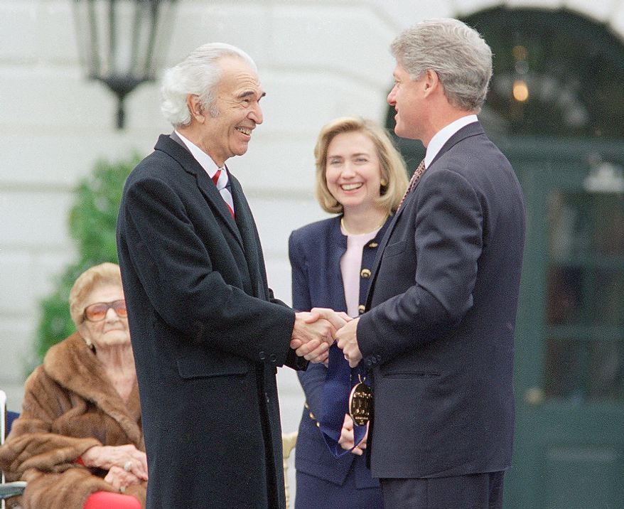 President Bill Clinton, right, shakes hands with jazz musician and composer Dave Brubeck during the 1994 National Medals of Arts ceremony at the White House, Friday, Oct. 14, 1994, Washington DC. The President presented Brubeck and others with at the 1994 National Medals of Arts. First lady Hillary Rodham Clinton looks on at center. Woman on far left is unidentified. (AP Photo/Joe Marquette)