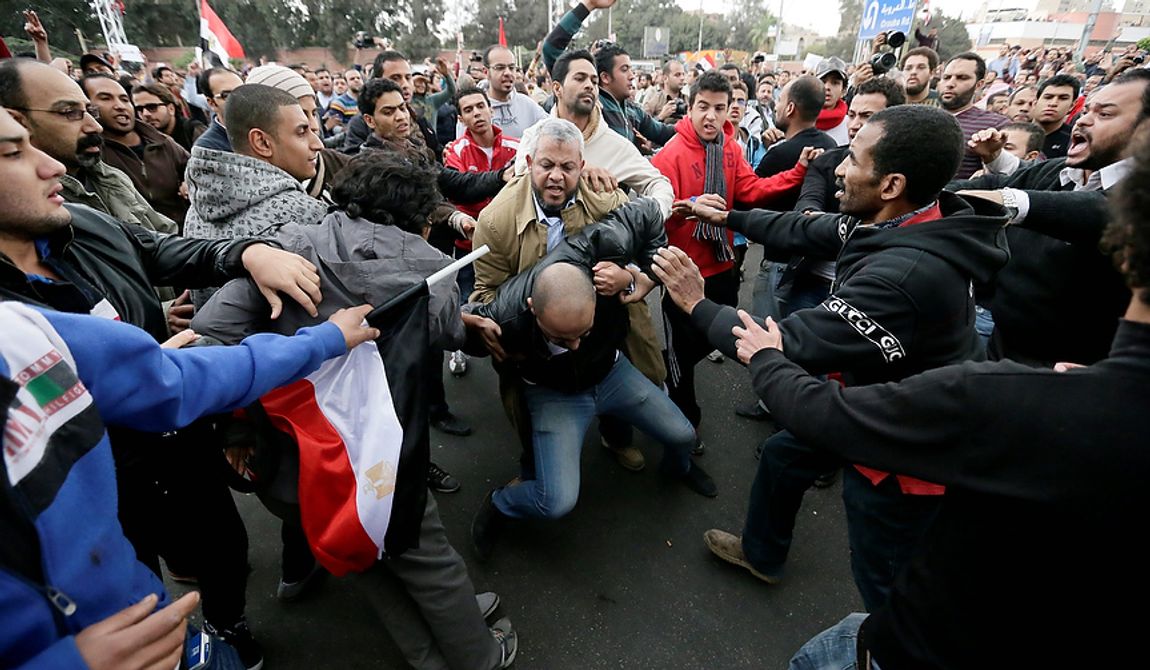 Egyptian President Mohammed Morsi&#x27;s supporters beat an opponent, center, during clashes outside the presidential palace, in Cairo, Egypt, Wednesday, Dec. 5, 2012. Wednesday&#x27;s clashes began when thousands of Islamist supporters of Morsi descended on the area around the palace where some 300 of his opponents were staging a sit-in. (AP Photo/Hassan Ammar)