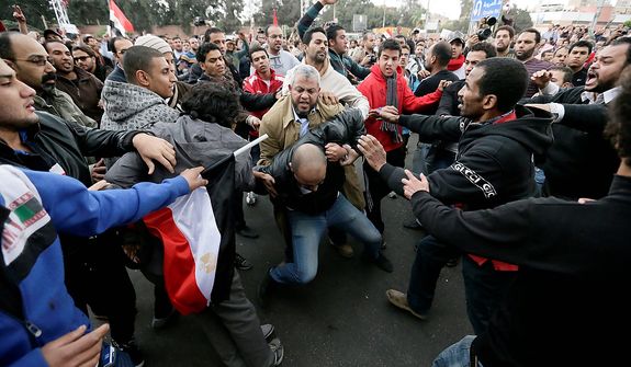 Egyptian President Mohammed Morsi&#39;s supporters beat an opponent, center, during clashes outside the presidential palace, in Cairo, Egypt, Wednesday, Dec. 5, 2012. Wednesday&#39;s clashes began when thousands of Islamist supporters of Morsi descended on the area around the palace where some 300 of his opponents were staging a sit-in. (AP Photo/Hassan Ammar)