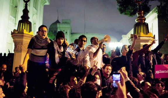 Egyptian protesters chant slogans against the Muslim Brotherhood during a rally Dec. 4, 2012, in front of the main gate of the presidential palace in Cairo. (Associated Press)