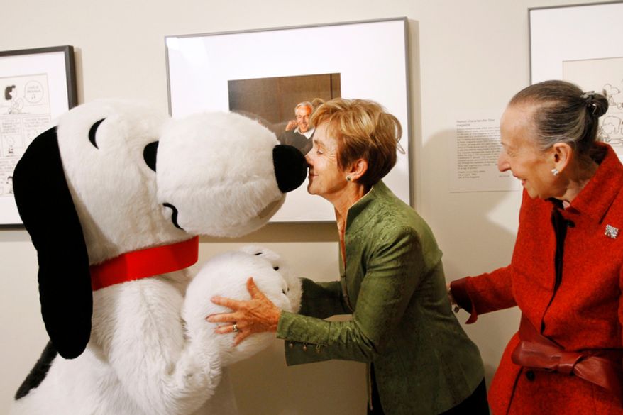 Jean Schulz (center), widow of cartoonist Charles M. Schulz, rubs noses with Snoopy in front of a portrait of the "Peanuts" creator by photographer Yousuf Karsh on Friday, Oct. 1, 2010, at the National Portrait Gallery in Washington, during a ceremony in which the portrait was presented to the gallery. Estrellita Karsh, wife of the photographer, is at right. (AP Photo/Jacquelyn Martin)