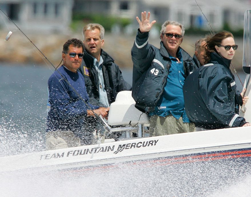 President George W. Bush waves as he stands next to his daughter Barbara as they pass by on his father's, former President George Bush, fishing boat Fidelity III, off the coast of Kennebunkport, Maine, on Saturday morning, June 30, 2007. Former President Bush pilots his boat as a Secret Service agent and his fishing guide, Billy Bush (left), stand behind. (AP Photo/Stephan Savoia)