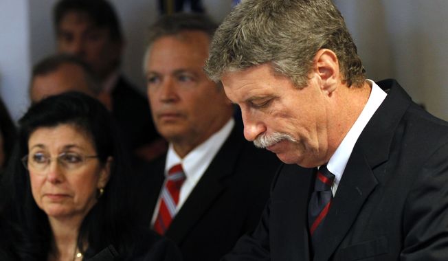 Jim Letten, U.S. attorney for the Eastern District of Louisiana, announces his resignation during a news conference in New Orleans on Thursday, Dec. 6, 2012. His wife, JoAnn, is at left. (AP Photo/Gerald Herbert)