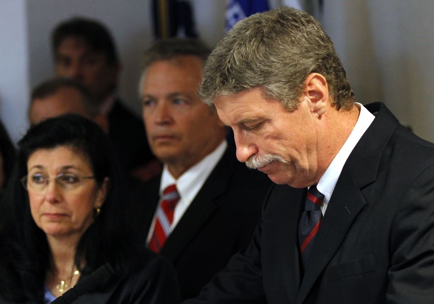 Jim Letten, U.S. attorney for the Eastern District of Louisiana, announces his resignation during a news conference in New Orleans on Thursday, Dec. 6, 2012. His wife, JoAnn, is at left. (AP Photo/Gerald Herbert)