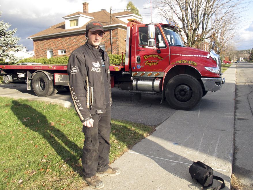 Nicholas Dostie stands Nov. 13, 2012, in front of his tow truck in Magog, Quebec, that he said he used to tow a van in which about a dozen men, women and children entered Canada illegally from the United States and applied for political asylum. Canadian immigration officials on Dec. 5, 2012 said a Romanian smuggling ring has been bringing Gypsies into the U.S. through Mexico in order for them to eventually gain asylum in Canada. (Associated Press)
