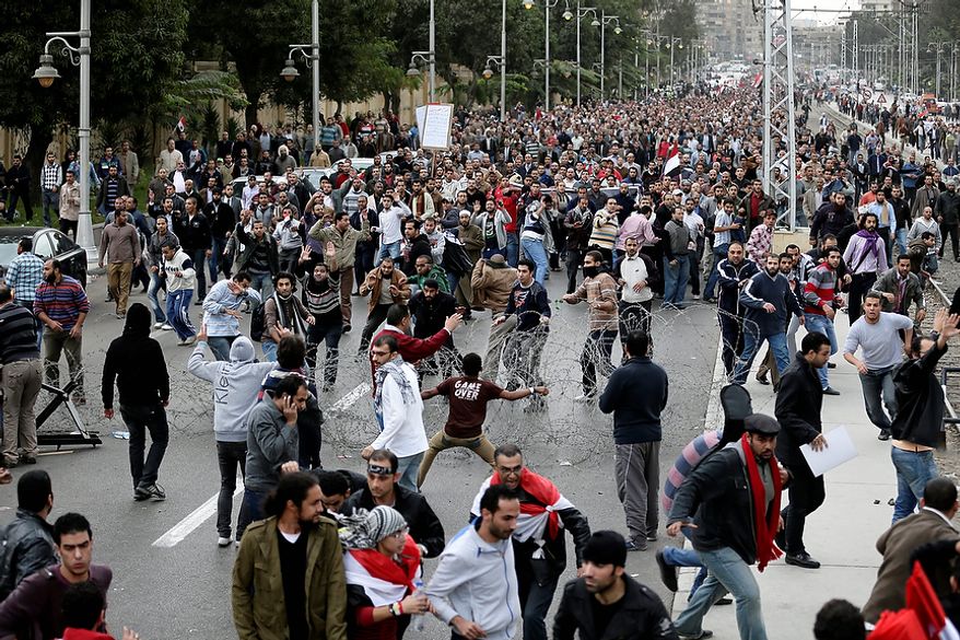 Supporters of Egyptian President Mohammed Morsi (background) clash with opponents (foreground) outside the presidential palace in Cairo on Dec. 5, 2012. The clashes began when thousands of Islamist supporters of Morsi descended on the area around the palace, where some 300 of his opponents were staging a sit-in. (Associated Press)