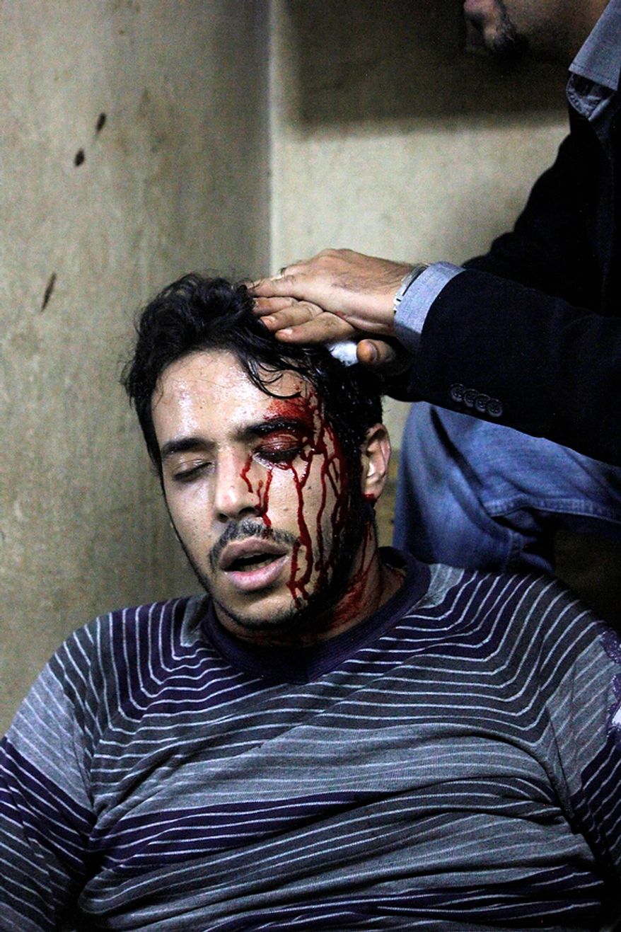 A wounded protester is treated after clashes between supporters and opponents of Egyptian President Mohammed Morsi outside the presidential palace in Cairo on Dec. 5, 2012. Supporters and opponents of Morsi fought with rocks, firebombs and sticks outside the palace in large-scale clashes that marked the worst violence of a deepening crisis over the disputed constitution. (Associated Press)