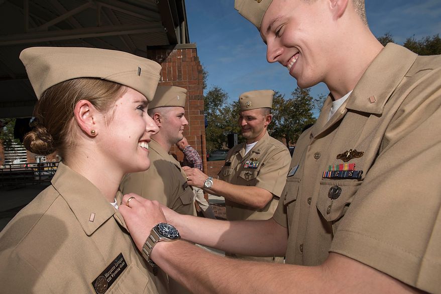 Lt. j.g. Luke Leveque, assigned to the Gold crew of the ballistic missile submarine USS Maryland (SSBN 738), pins the submarine officer warfare device on his wife, Lt. j.g. Marquette Leveque, assigned to the Gold crew of the ballistic missile submarine USS Wyoming (SSBN 742), at Naval Submarine Base Kings Bay on Dec. 5, 2012. Leveque is one of three sailors to become the first female unrestricted line officers to qualify in submarines. (Mass Communication Specialist 1st Class James Kimber/U.S. Navy)