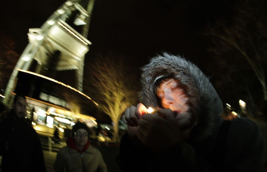 C. Nash smokes marijuana in a glass pipe on Thursday, Dec. 6, 2012, just after midnight at the Space Needle in Seattle, after the possession of marijuana became legal in Washington state. (AP Photo/Ted S. Warren)