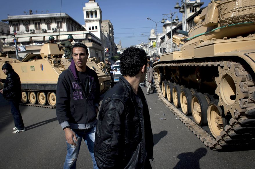 Egyptian Army tanks deploy near the presidential palace in Cairo on Dec. 6, 2012, to secure the site of overnight clashes between supporters and opponents of President Mohammed Morsi. (Associated Press)