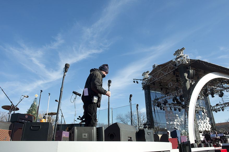 A member of the stage crew sets microphones in place on Dec. 6, 2012, during setup and rehearsal for the lighting of the National Christmas tree on the Ellipse in downtown D.C. later that evening. (Barbara L. Salisbury/The Washington Times)